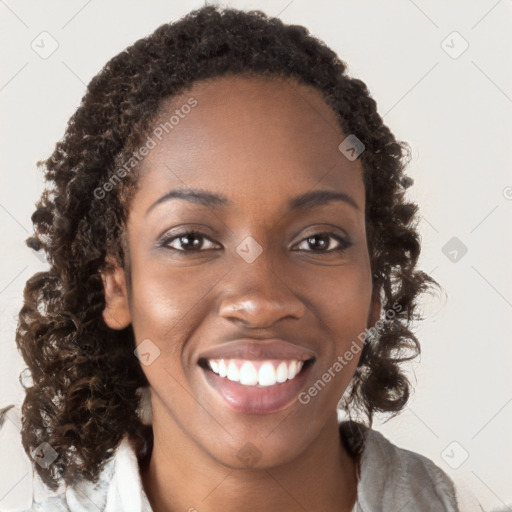 Joyful black young-adult female with long  brown hair and brown eyes