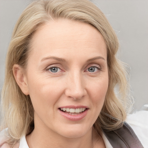 Joyful white adult female with medium  blond hair and blue eyes