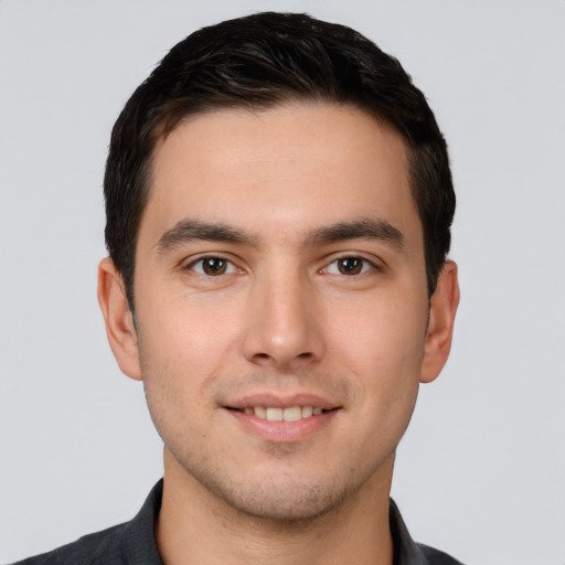 Joyful white young-adult male with short  black hair and brown eyes