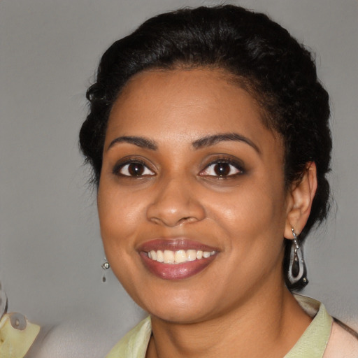 Joyful black young-adult female with short  brown hair and brown eyes
