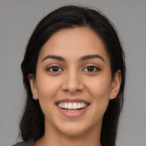 Joyful latino young-adult female with long  brown hair and brown eyes