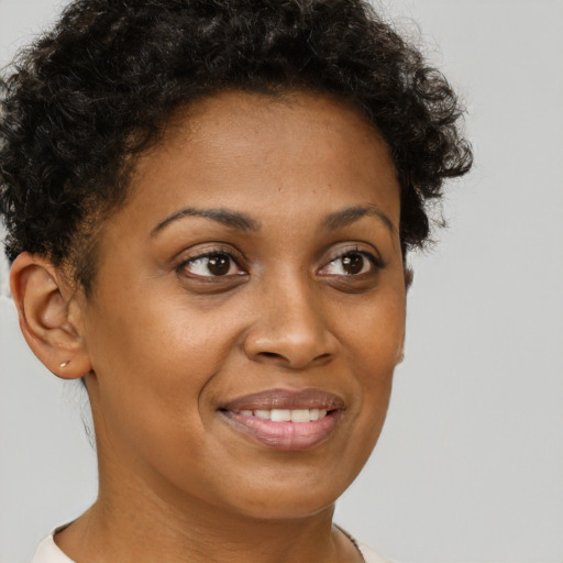 Joyful black young-adult female with short  brown hair and brown eyes