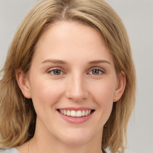 Joyful white young-adult female with long  brown hair and blue eyes