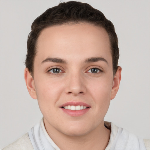 Joyful white young-adult female with short  brown hair and grey eyes