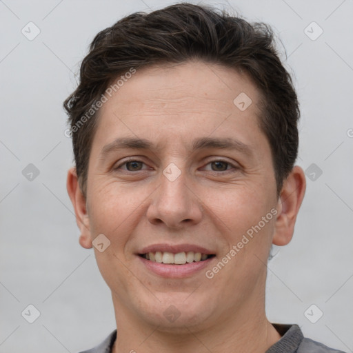 Joyful white adult male with short  brown hair and grey eyes