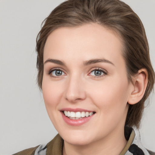 Joyful white young-adult female with medium  brown hair and grey eyes