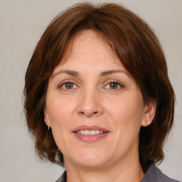 Joyful white adult female with medium  brown hair and grey eyes