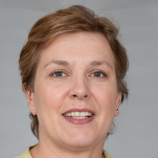 Joyful white adult female with medium  brown hair and blue eyes