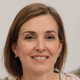 Joyful white adult female with medium  brown hair and grey eyes