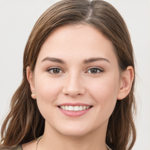 Joyful white young-adult female with long  brown hair and grey eyes