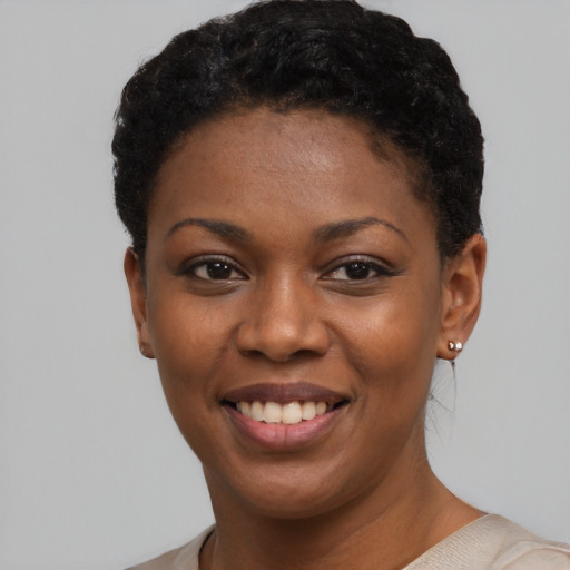 Joyful black young-adult female with short  black hair and brown eyes