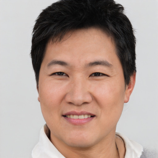 Joyful asian adult male with short  brown hair and brown eyes