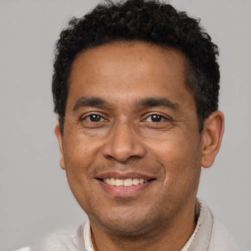 Joyful black adult male with short  black hair and brown eyes