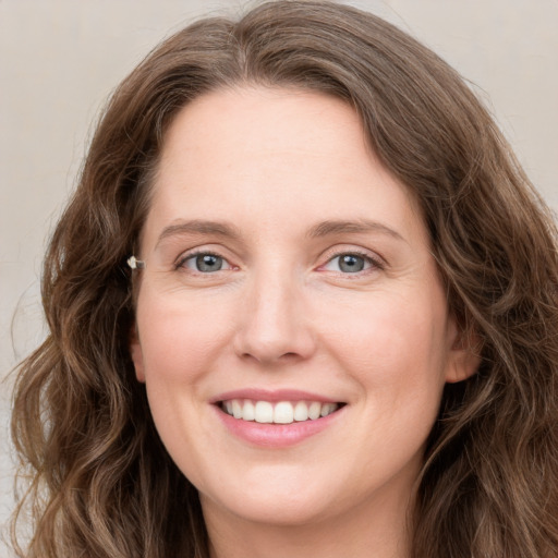 Joyful white young-adult female with long  brown hair and green eyes