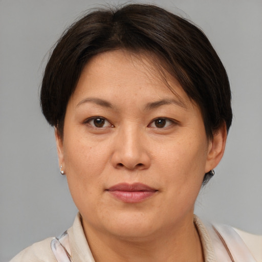 Joyful asian adult female with medium  brown hair and brown eyes