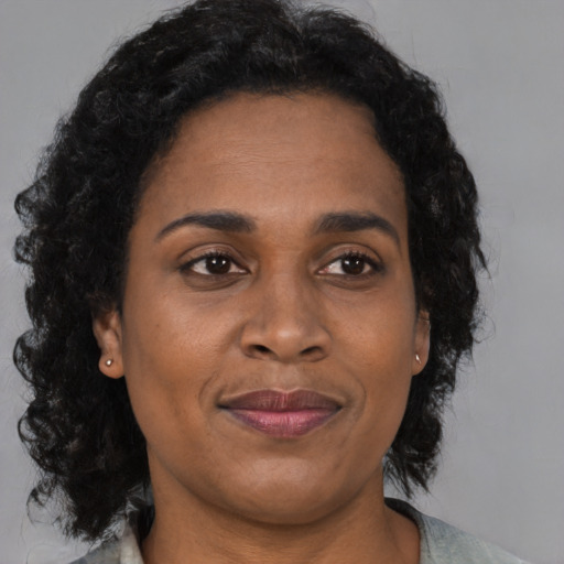Joyful black adult female with medium  brown hair and brown eyes