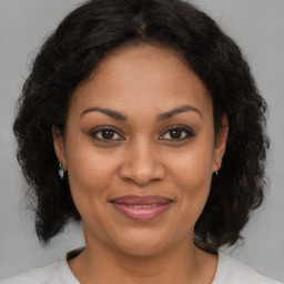 Joyful black adult female with medium  brown hair and brown eyes