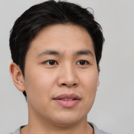 Joyful asian young-adult male with short  brown hair and brown eyes