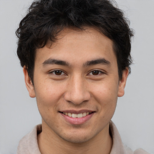 Joyful asian young-adult male with short  brown hair and brown eyes