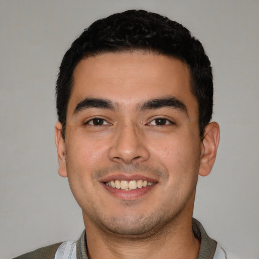 Joyful latino young-adult male with short  black hair and brown eyes