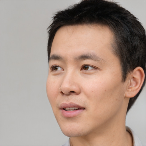 Joyful white young-adult male with short  black hair and brown eyes