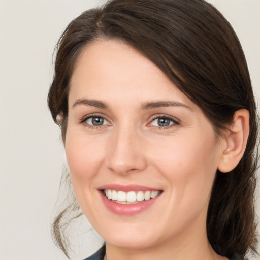 Joyful white young-adult female with medium  brown hair and grey eyes