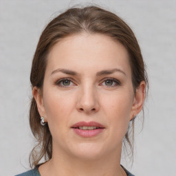 Joyful white young-adult female with medium  brown hair and grey eyes