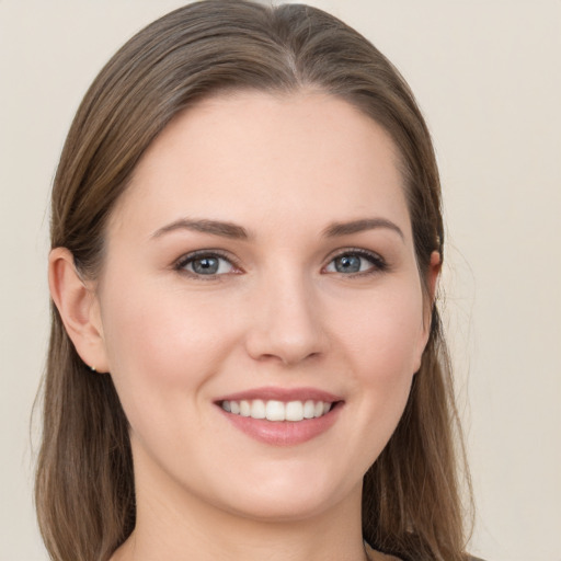 Joyful white young-adult female with long  brown hair and grey eyes