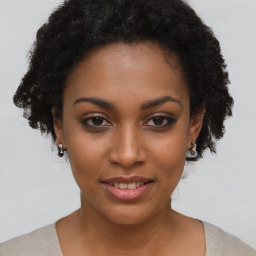 Joyful black young-adult female with short  brown hair and brown eyes