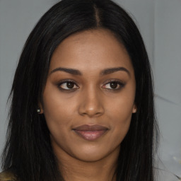 Joyful black young-adult female with long  brown hair and brown eyes