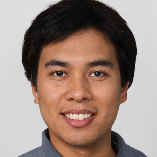 Joyful asian young-adult male with short  black hair and brown eyes