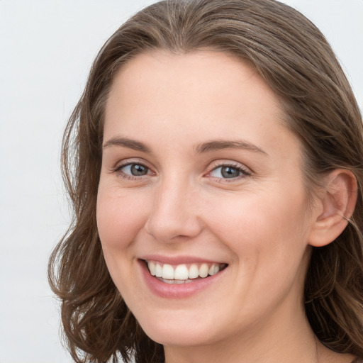 Joyful white young-adult female with long  brown hair and grey eyes