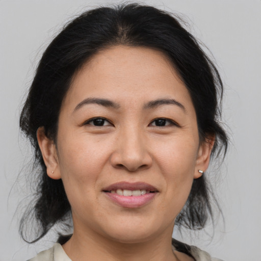 Joyful asian adult female with medium  brown hair and brown eyes