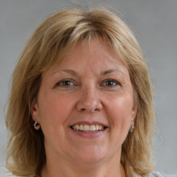 Joyful white adult female with medium  brown hair and blue eyes