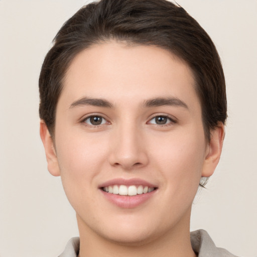 Joyful white young-adult female with short  brown hair and brown eyes