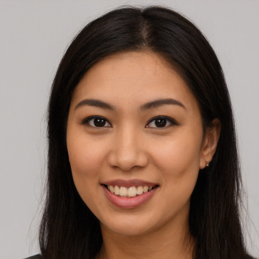 Joyful latino young-adult female with long  brown hair and brown eyes