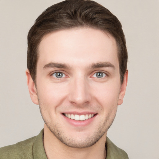 Joyful white young-adult male with short  brown hair and grey eyes