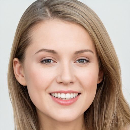 Joyful white young-adult female with long  brown hair and grey eyes