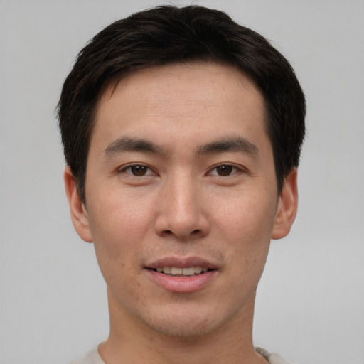 Joyful asian young-adult male with short  brown hair and brown eyes