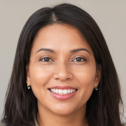 Joyful latino young-adult female with long  brown hair and brown eyes