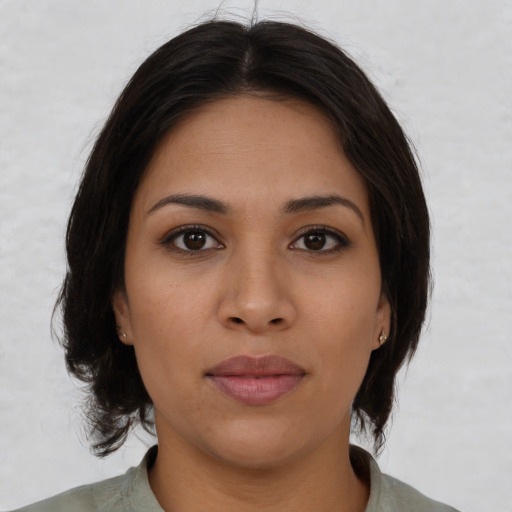 Joyful latino young-adult female with medium  brown hair and brown eyes