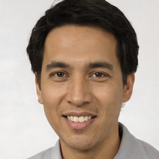 Joyful asian young-adult male with short  black hair and brown eyes