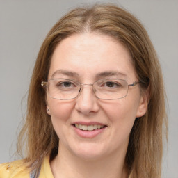 Joyful white adult female with long  brown hair and blue eyes