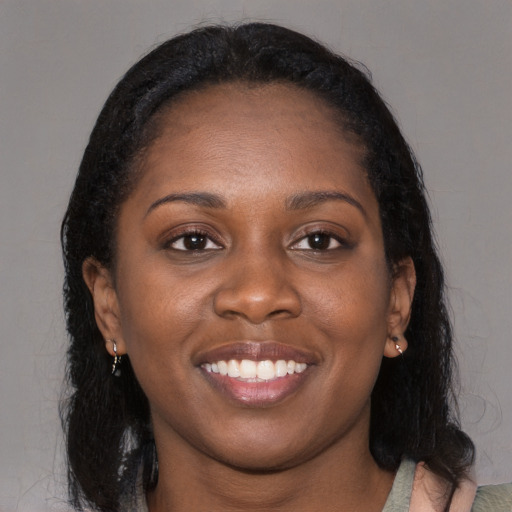Joyful black young-adult female with long  black hair and brown eyes