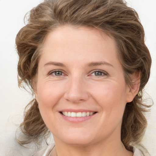 Joyful white young-adult female with medium  brown hair and green eyes