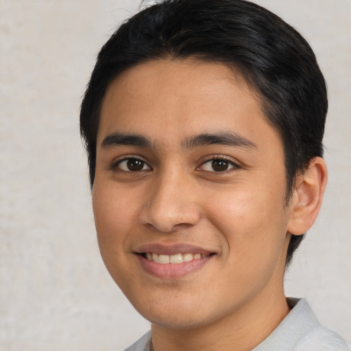 Joyful latino young-adult male with short  black hair and brown eyes