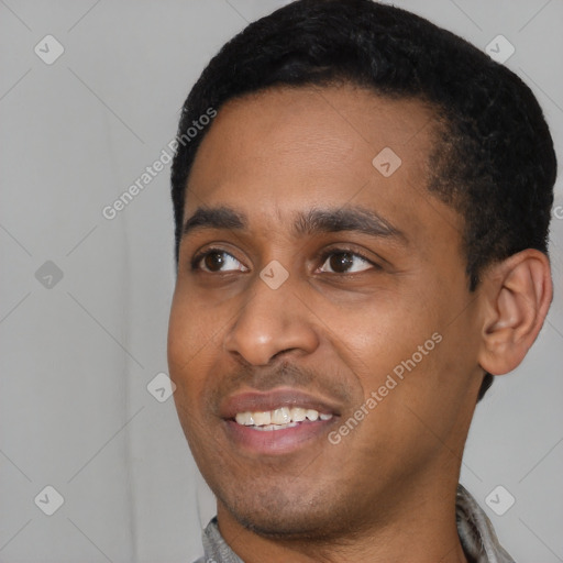 Joyful black young-adult male with short  black hair and brown eyes