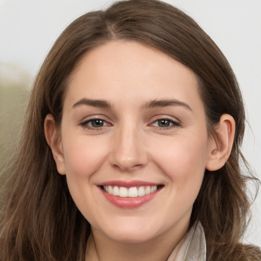 Joyful white young-adult female with long  brown hair and grey eyes