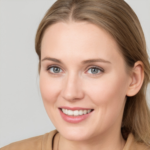 Joyful white young-adult female with long  brown hair and blue eyes