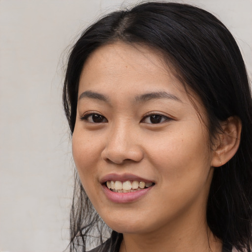 Joyful asian young-adult female with long  black hair and brown eyes
